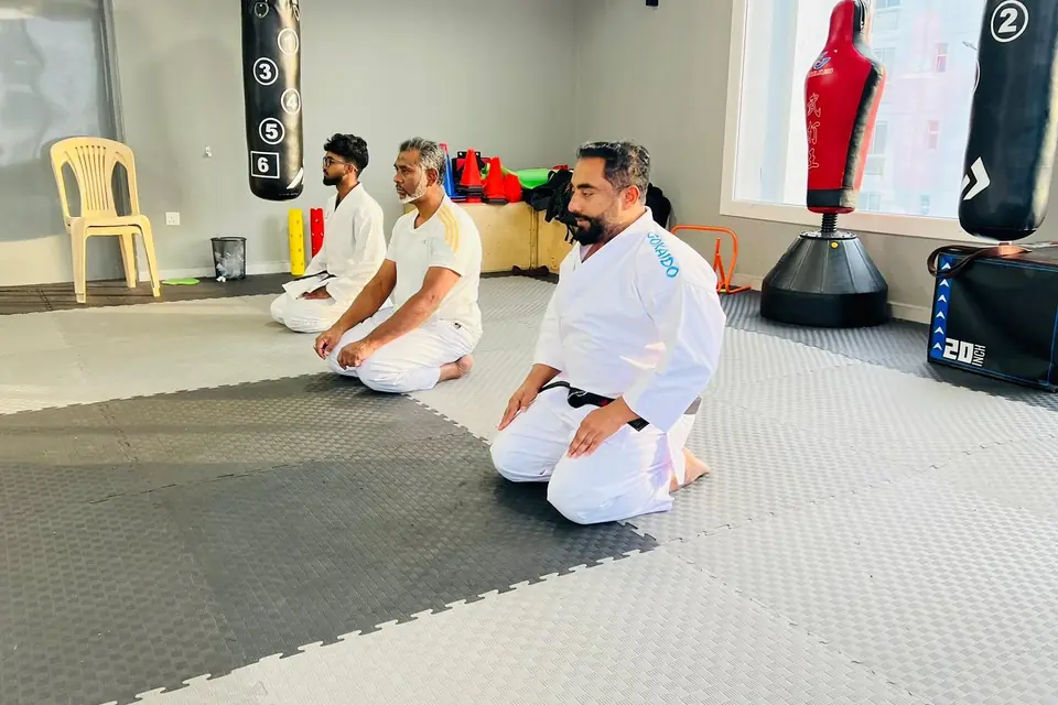 Instructors kneeling in quiet meditation before class